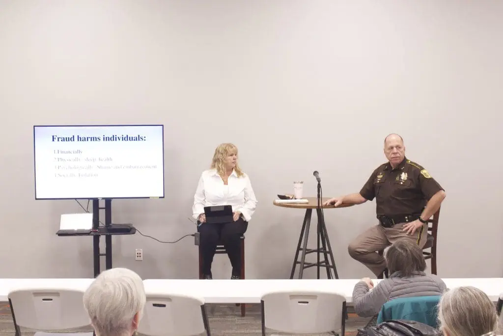 A woman and a sheriff offering a free senior seminar about fraud
