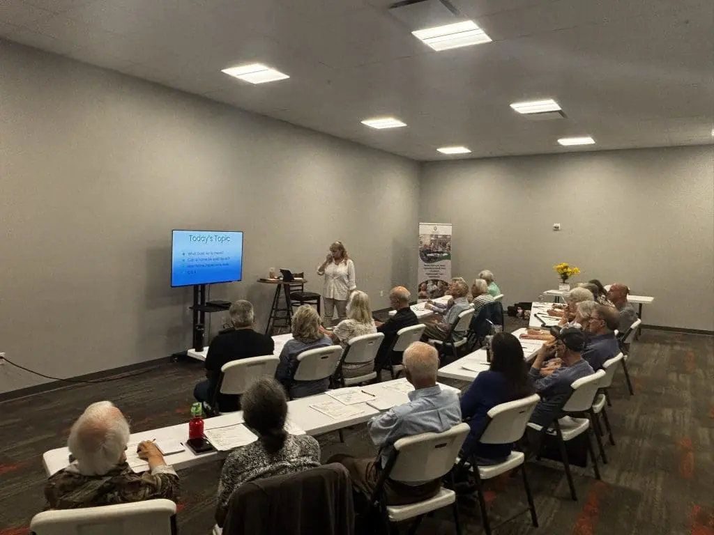people seated around white tables at a seminar