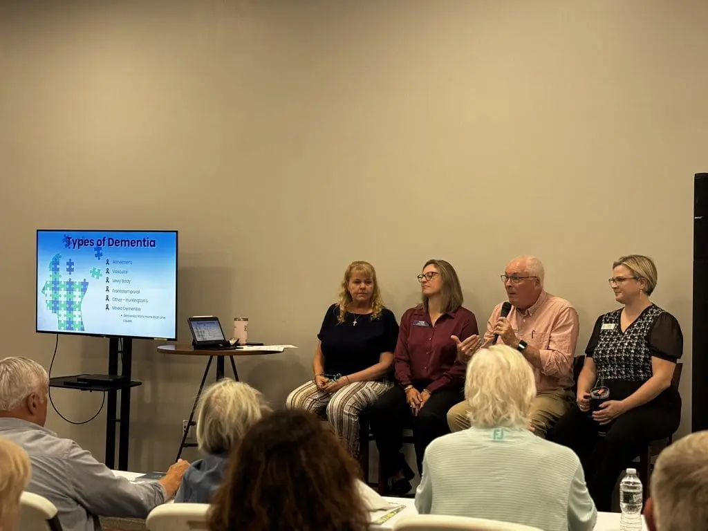 4 panelists sit in the front of a class at a free senior education program