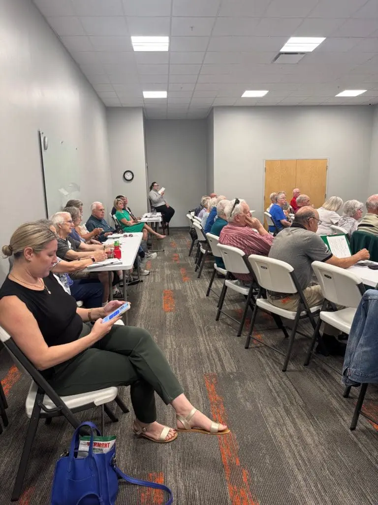 People sitting in white chairs at a Free educational seminar for seniors in Portland Maine